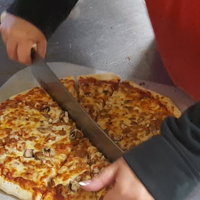 Mushroom pizza being sliced fresh